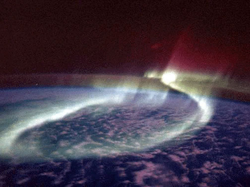 A sinuous glowing band of <a
  href="/earth/Magnetosphere/aurora.html&dev=">aurora</a> (the Aurora Australis
  or Southern Lights) loops around the <a
  href="/earth/polar/polar_south.html&dev=">southern polar</a>
region in the
  distance as viewed by astronauts onboard the space shuttle on <a
  href="http://www.nasa.gov/mission_pages/shuttle/shuttlemissions/archives/sts-39.html">STS-039</a>. 
  <a
  href="/earth/Magnetosphere/aurora/aurora_colors.html&dev=">Aurora are produced</a>
  when <a
  href="/physical_science/physics/atom_particle/particle_radiation.html&dev=">energetic particles</a>
 entering the Earth's
  atmosphere from space interact with <a
  href="/physical_science/physics/atom_particle/atom.html&dev=">atoms</a> and <a
  href="/earth/geology/molecule.html&dev=">molecules</a> in the atmosphere and
  release energy, emitted as light.<p><small><em>Courtesy of NASA, Astronaut Overmeyer and Dr. Hallinan</em></small></p>